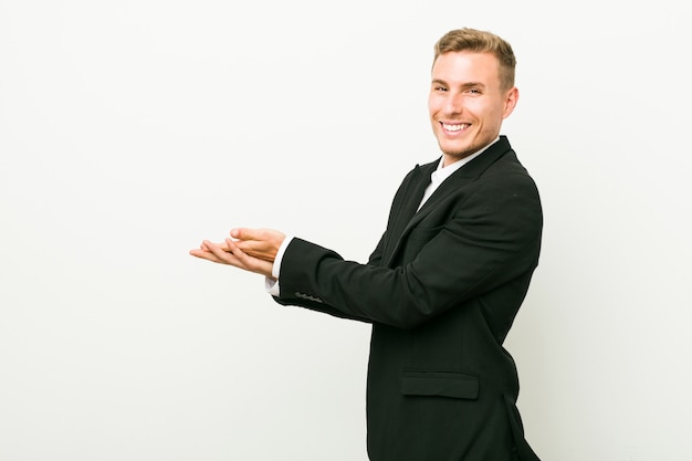 Young caucasian business man holding a copy space on a palm.