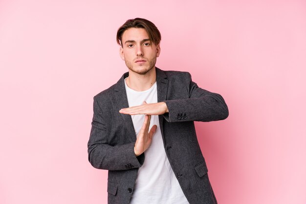 Young caucasian business man posing isolated showing a timeout gesture.