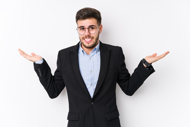 Young caucasian business man posing in a white wall isolated Young caucasian business man confused and doubtful shrugging shoulders to hold a copy space.