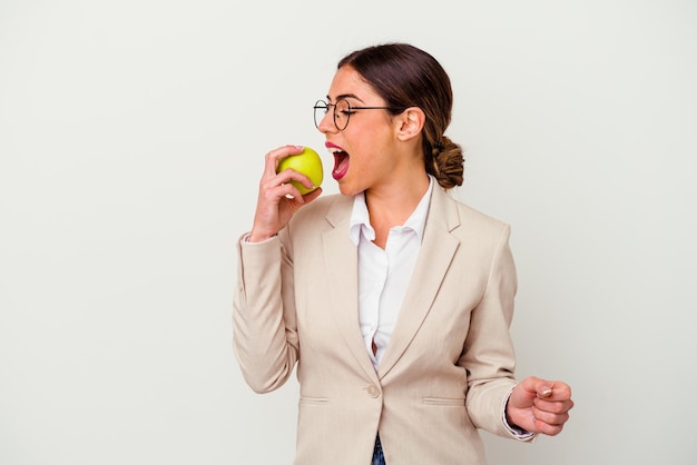 孤立したリンゴを食べる若い白人ビジネスウーマン