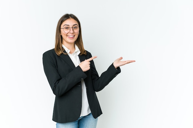 Young caucasian business woman excited holding a copy space on palm.