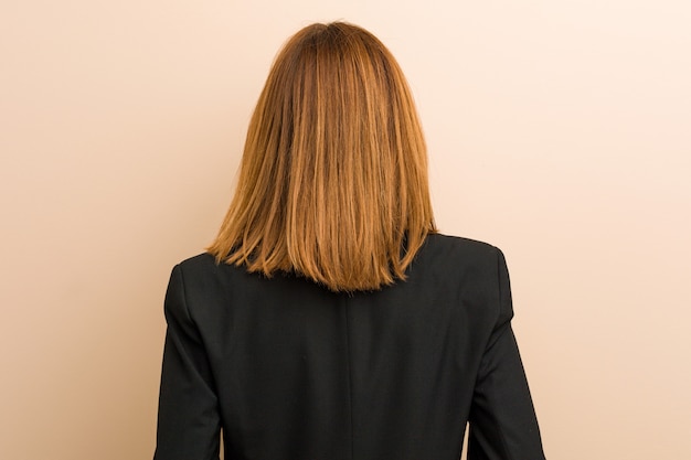 Young caucasian business woman from behind, looking back.