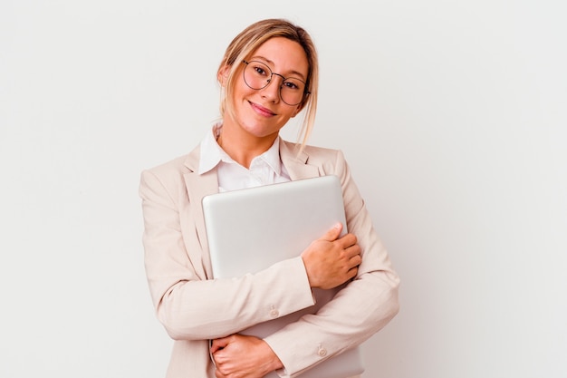 Young caucasian business woman holding a laptop isolated on white background happy, smiling and cheerful.