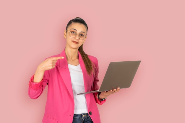 young caucasian business woman holding laptop Pointing index finger to modern computer
