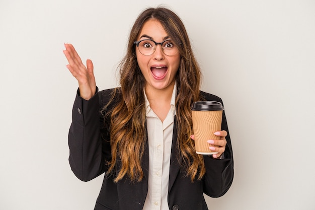 Young caucasian business woman holding a takeaway coffee isolated on white background receiving a pleasant surprise, excited and raising hands.