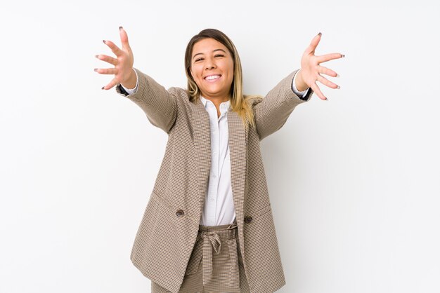 Young caucasian business woman isolated feels confident giving a hug to the camera.