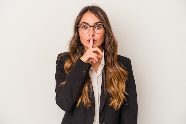 Young caucasian business woman isolated on white background keeping a secret or asking for silence.