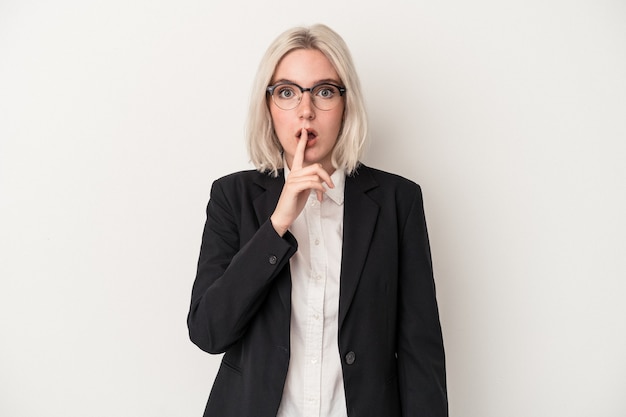 Young caucasian business woman isolated on white background keeping a secret or asking for silence.