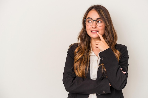 Young caucasian business woman isolated on white background relaxed thinking about something looking at a copy space.