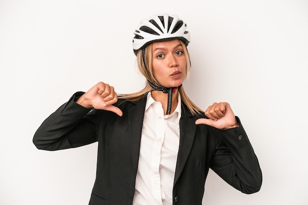 흰색 배경에 격리된 자전거 헬멧을 쓴 젊은 백인 사업가는 따라야 할 본보기인 자부심과 자신감을 느낍니다.