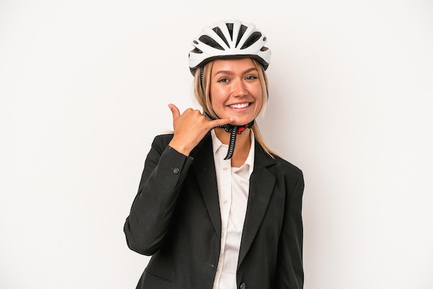 Giovane donna caucasica di affari che indossa un casco della bici isolato su fondo bianco che mostra un gesto di chiamata del telefono cellulare con le dita.