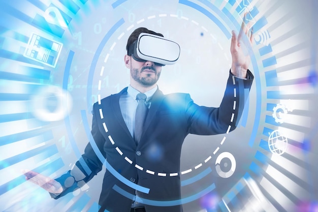 Young caucasian businessman with beard wearing virtual reality glasses working with immersive digital interface and hud over white background. Toned image double exposure