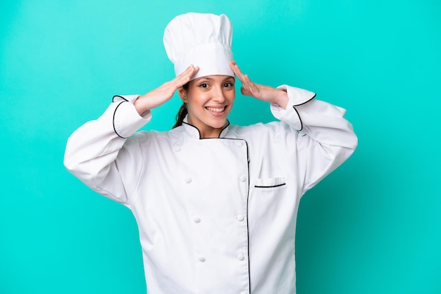 Young caucasian chef woman isolated on blue background with surprise expression