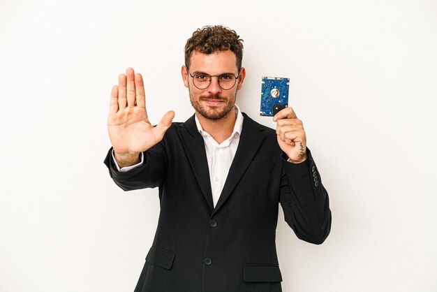 Young caucasian computerized holding HDD isolated on white background standing with outstretched hand showing stop sign, preventing you.