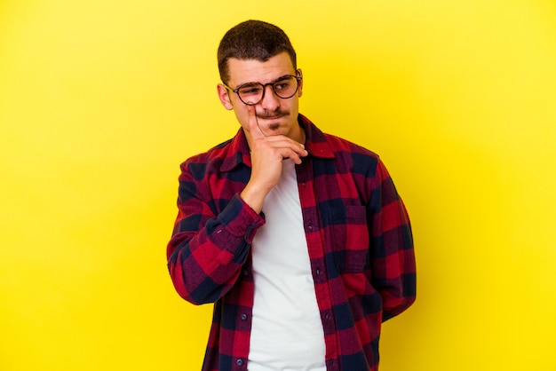 Young caucasian cool man on yellow contemplating, planning a strategy, thinking about the way of a business.