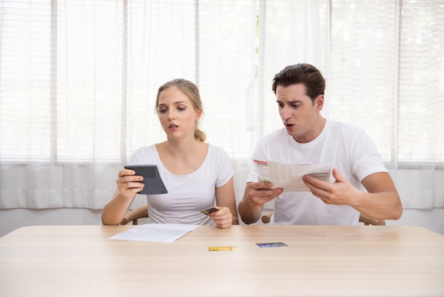 Young caucasian couple hand holding credit card and debt bill