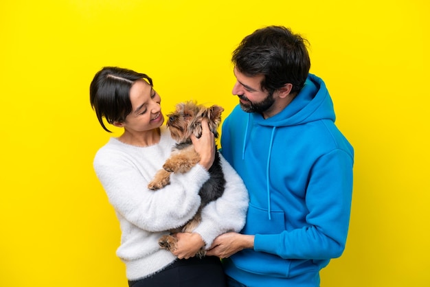 Young caucasian couple holding a dog