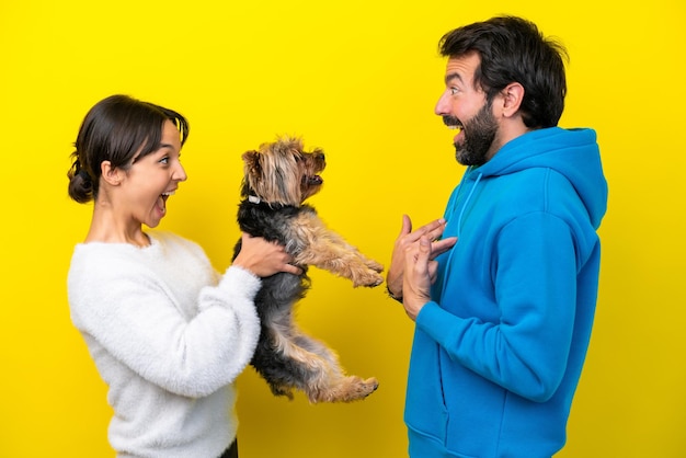 Young caucasian couple holding a dog