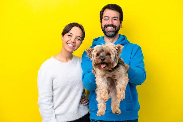 Young caucasian couple holding a dog