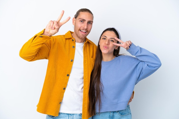 Young caucasian couple isolated on white background smiling and showing victory sign