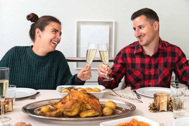 Young caucasian couple toasting with champagne in Christmas family reunion dinner Holiday Romance