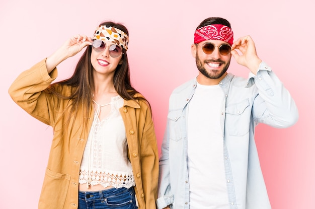 Young caucasian couple wearing a music festival clothes isolated excited keeping ok gesture on eye.