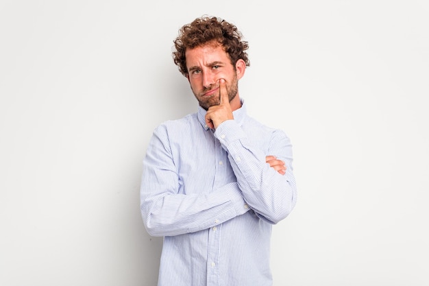 young caucasian curly hair man isolated on white background unhappy looking in camera