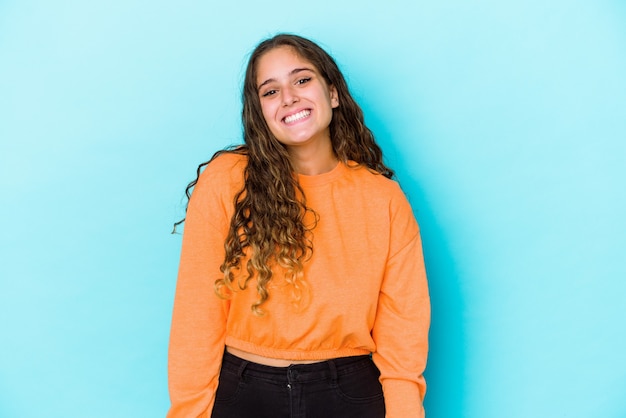 Young caucasian curly hair woman isolated laughs and closes eyes, feels relaxed and happy.