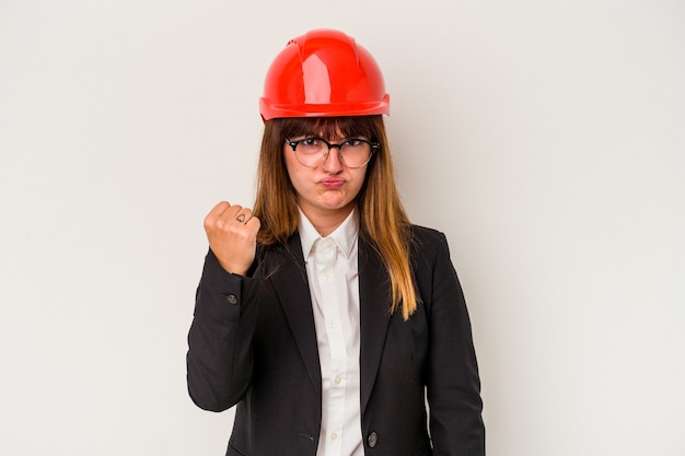 Young caucasian curvy architect woman isolated on white background showing fist to camera, aggressive facial expression.