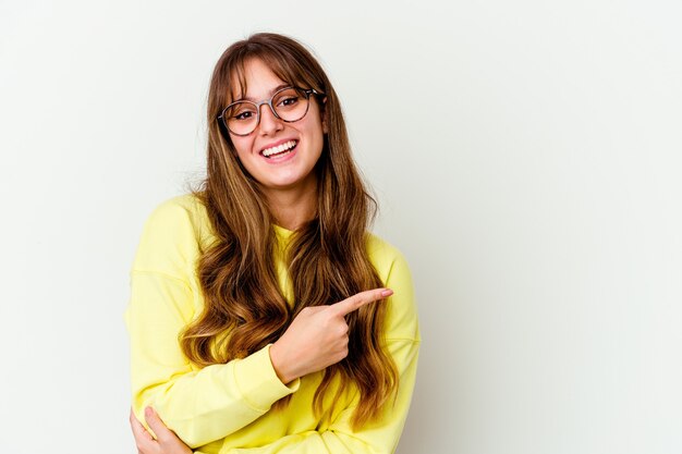 Young caucasian cute woman isolated on white background smiling cheerfully pointing with forefinger away.