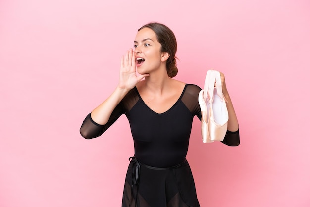 Photo young caucasian dance woman doing ballet isolated on pink background shouting with mouth wide open to the side