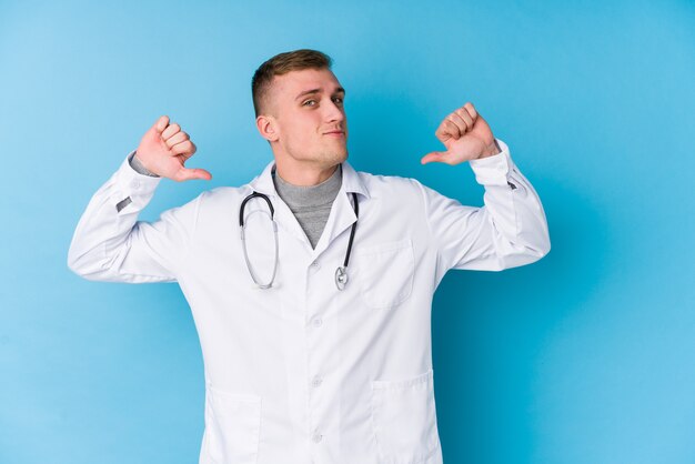 Young caucasian doctor man feels proud and self confident, example to follow.