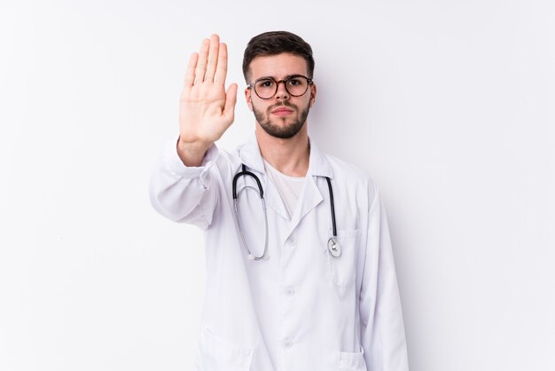 Giovane uomo caucasico di medico che sta con il fanale di arresto di rappresentazione della mano tesa