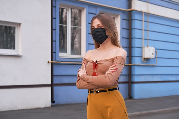 Young Caucasian European girl 20 years old wearing black protective medical mask protection against epidemic coronavirus covid-19