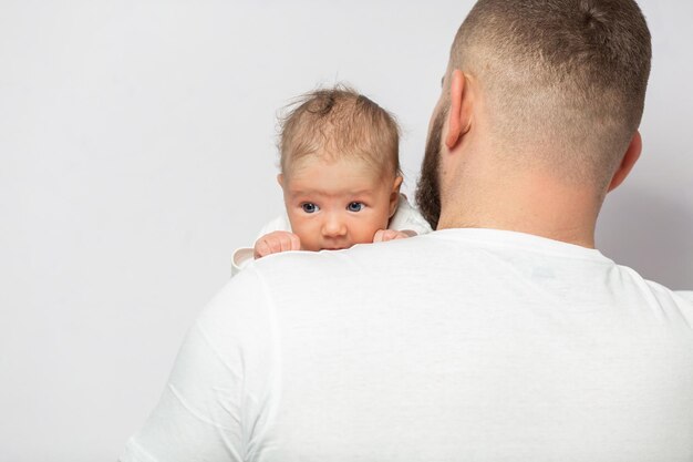 La giovane famiglia caucasica con la posa della figlia piccola si rilassa sul pavimento nel soggiorno sorridente bambina bambino abbraccio abbraccio genitori mostrano amore e gratitudine riposano a casa insieme