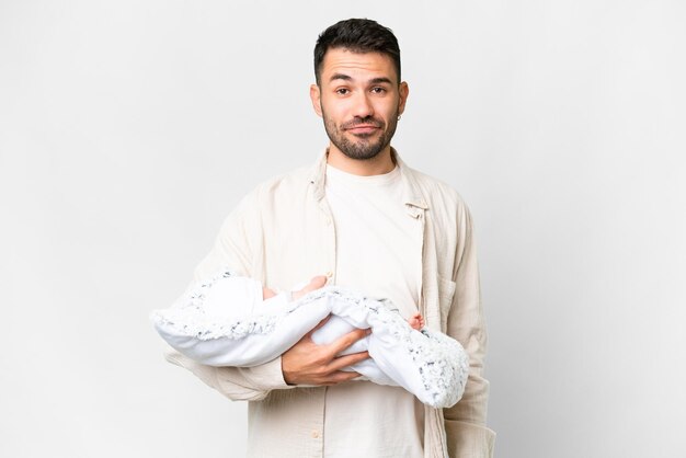 Young caucasian father with her newborn baby over isolated background with sad expression