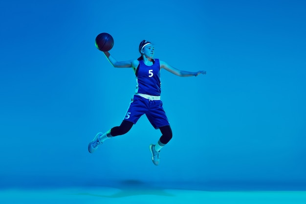 Photo young caucasian female basketball player isolated on blue in neon light