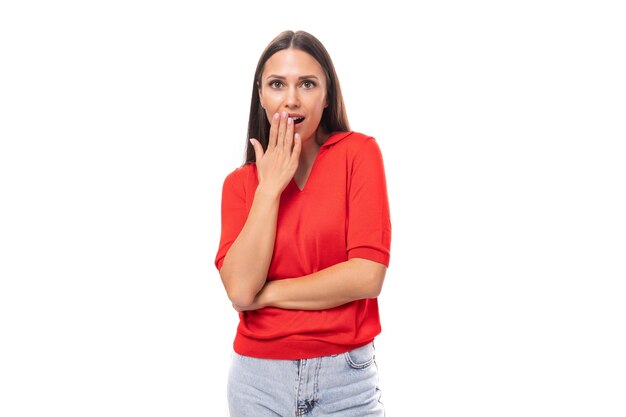 Young caucasian female model with black straight hair dressed in a red tshirt looks surprised on a