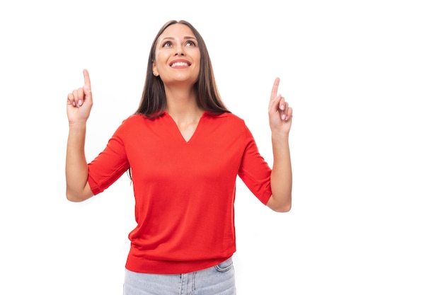 Young caucasian female model with black straight hair dressed in a red tshirt points with her hand