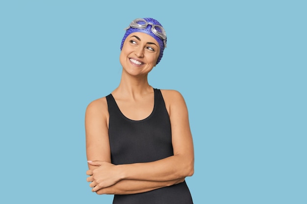 Young Caucasian female professional swimmer smiling confident with crossed arms