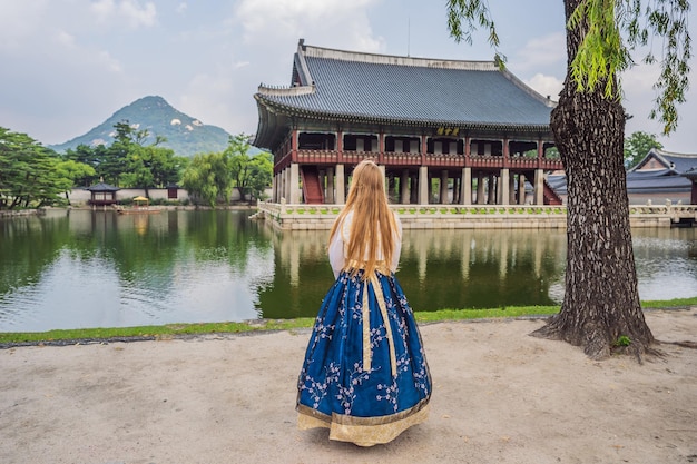 Фото Молодая кавказская туристка в национальном корейском платье ханбок в корейском дворце концепция путешествия в корею национальная корейская одежда развлечения для туристов, примеряющих национальную корейскую одежду