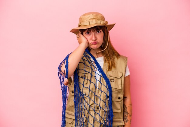 Young caucasian fisherwoman holding net isolated on blue background being shocked, she has remembered important meeting.