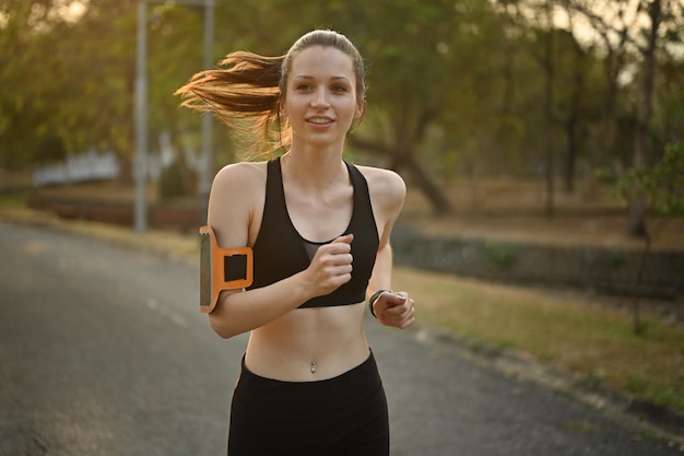 Молодая кавказская фитнес-женщина, бегущая по дорожке в общественном парке