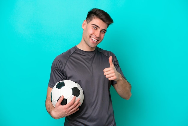 파란색 배경에 고립 된 젊은 백인 축구 선수 남자 제스처를 엄지손가락을 포기