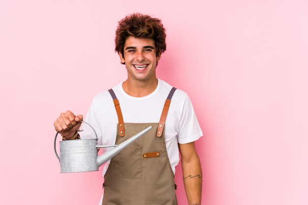 Young caucasian gardener man isolated happy, smiling and cheerful.