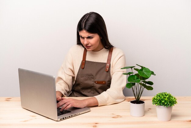 Young caucasian gardener woman working on the table isolated on white background