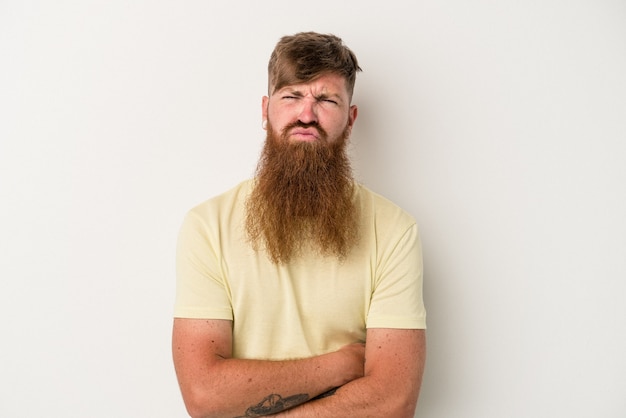 Young caucasian ginger man with long beard isolated on white background blows cheeks, has tired expression. Facial expression concept.