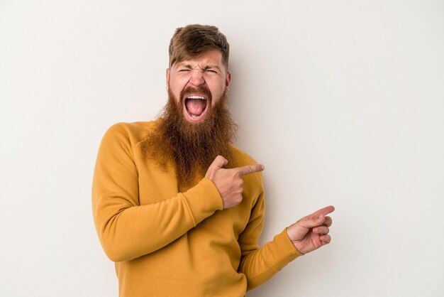 Young caucasian ginger man with long beard isolated on white background pointing with forefingers to a copy space, expressing excitement and desire.