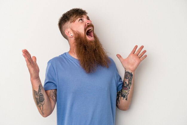 Young caucasian ginger man with long beard isolated on white background screaming to the sky, looking up, frustrated.