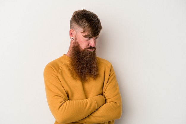 Young caucasian ginger man with long beard isolated on white\
background tired of a repetitive task.